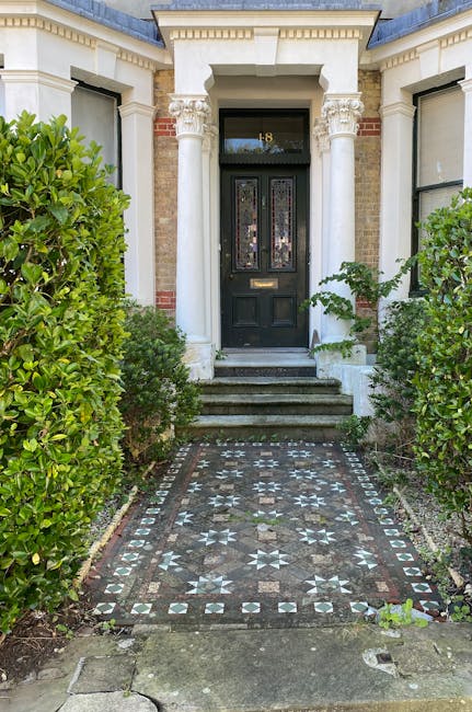 The image depicts the front entrance of a classic Victorian-style residential building in Islington, featuring a black wooden door with decorative glass panels and a brass letterbox. The entrance is f